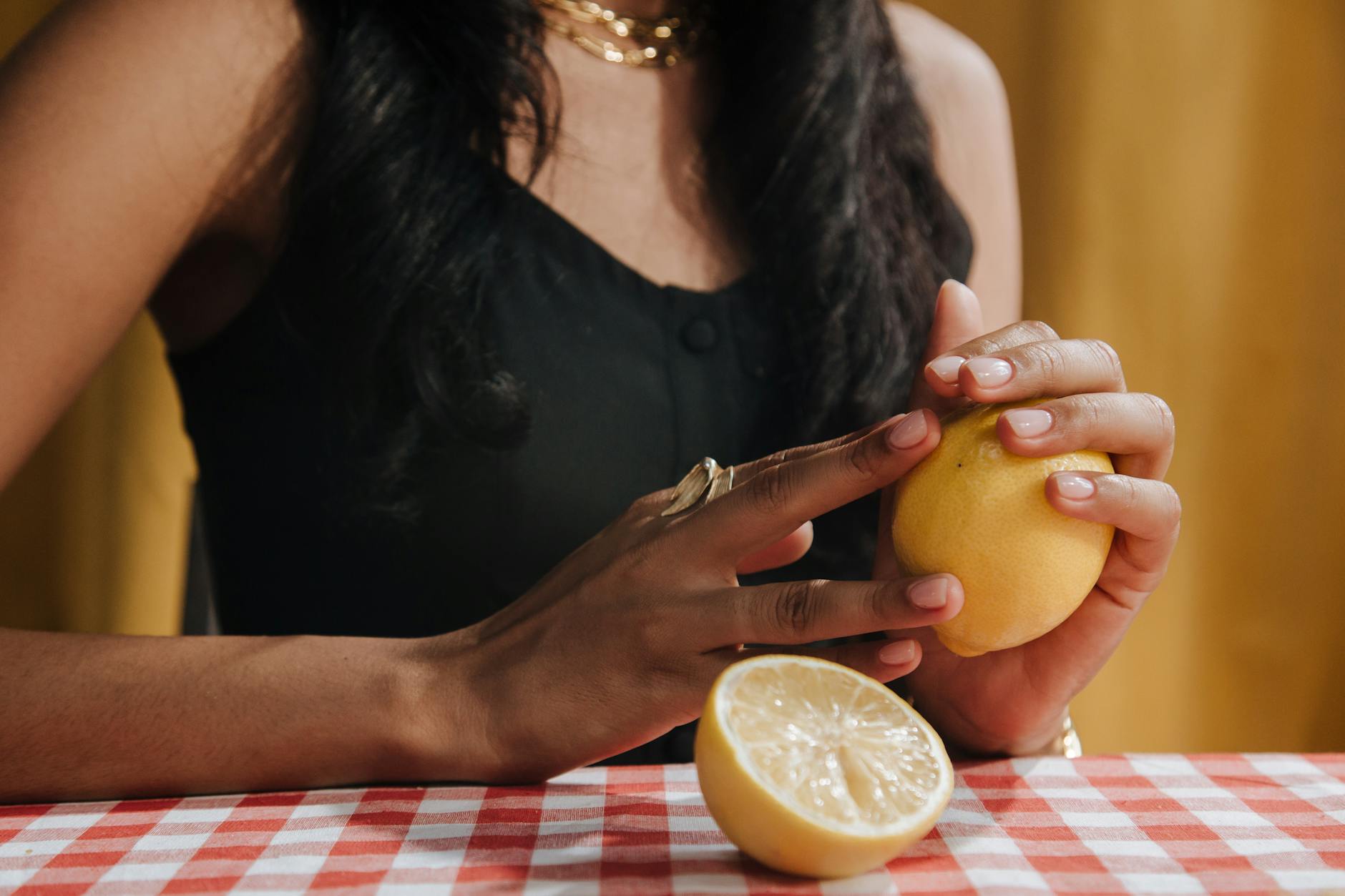 A person holding a fresh lemon, symbolizing the bright, straightforward approach to introducing vibrators in new relationships