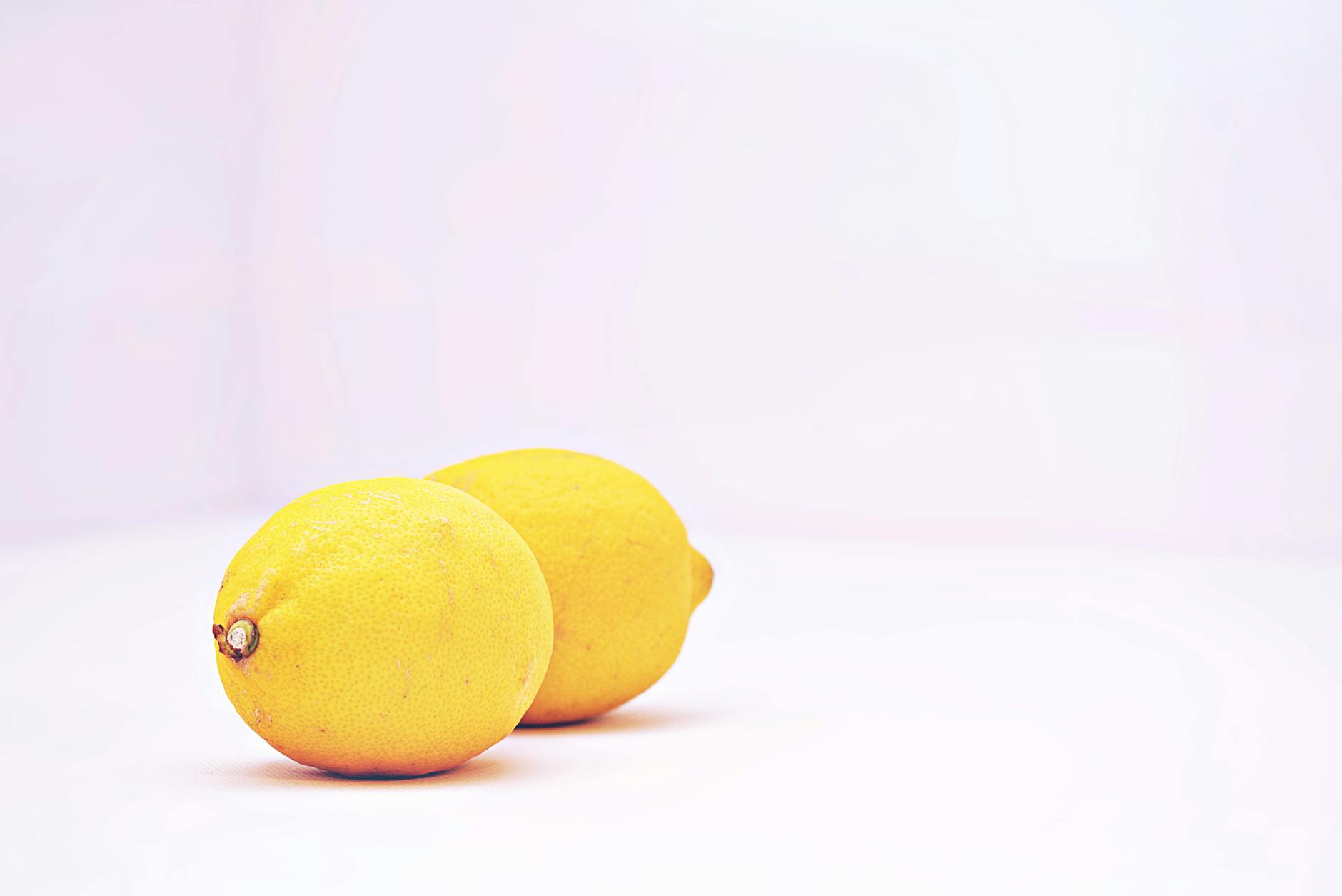 Blue vibrator surrounded by flowers and citrus slices on a bright yellow background, symbolizing pleasure and sensory change.