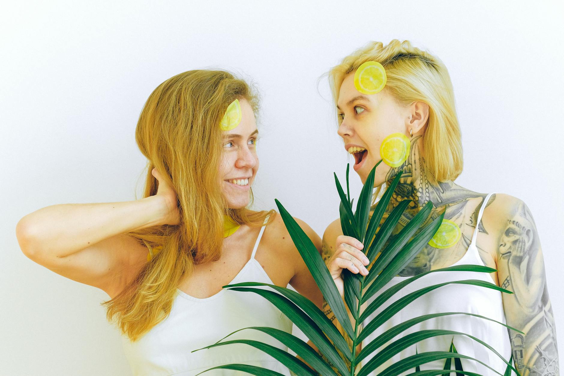 Two women laughing together with fresh lemons, representing joy and comfort in long-term relationships