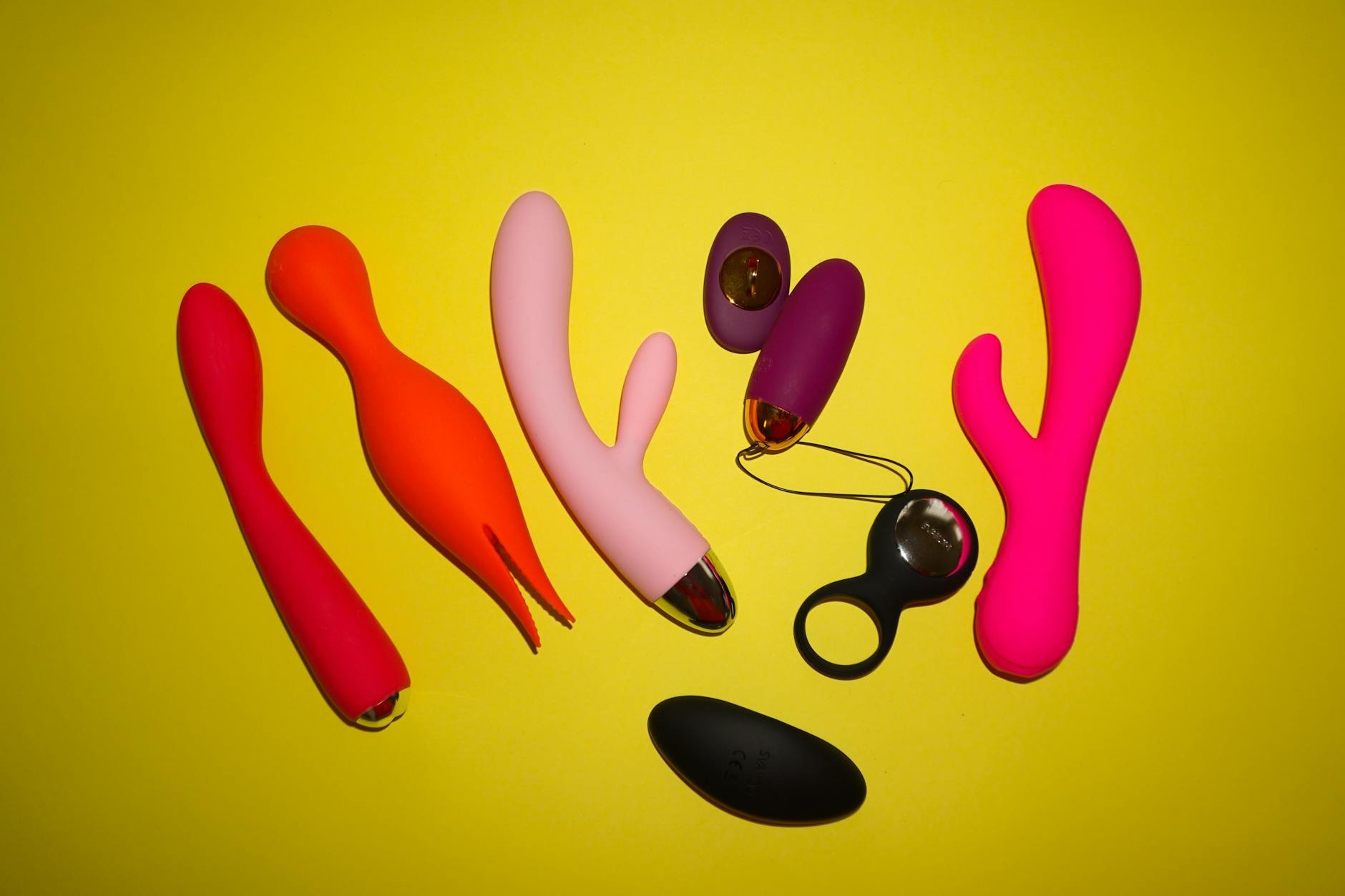 Woman holding two colorful vibrators, considering intimacy tools for reconnection